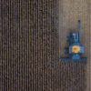 An overhead view of a harvesting machine collecting grain.