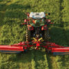 A Massey Ferguson DM series triple mower cuts through high grass in a field.